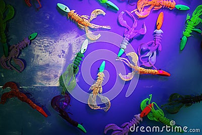 Silicone bait for catching predatory fish is painted with phosphoric paint. Demonstration of modern technologies using ultraviolet Stock Photo