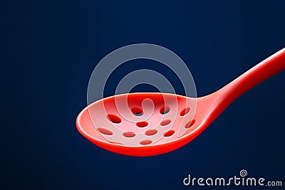 Silicone kitchen skimmer on dark blue background Stock Photo