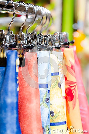 Silk scarfs on hangers in retail boutique shop Stock Photo