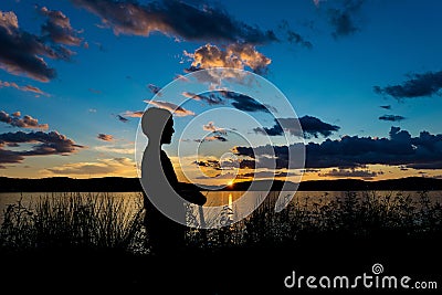 Sillhouette of a boy on a scooter during sunset, looking across the Hudson River, Tarrytown, Upstate New York, NY Stock Photo