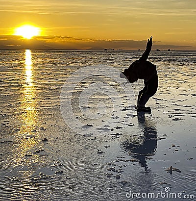 Sillouette of acrobat at sunrise on Bolivia Salt Flats Stock Photo