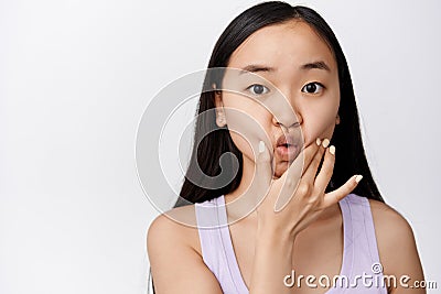 Silly young asian woman poking and sqeezing her face, pucker lips cute, making funny adorable facial expression, white Stock Photo