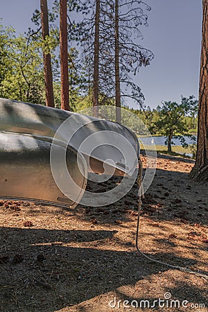 Silver aluminum canoes at a mountain lake in Southern California with pine trees Stock Photo