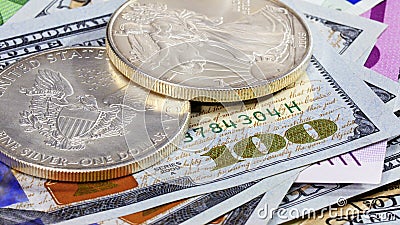Silver American dollar coins over different bank notes Stock Photo