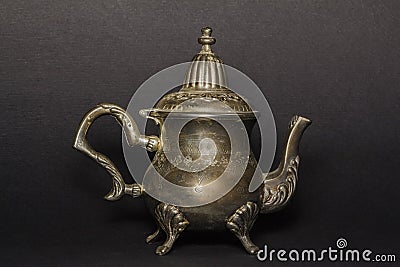 Silver antique kettle on a black background. Chaika made of silver. An antique teapot for tea. Stock Photo