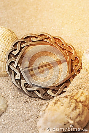 Silver antique old Celtic scarf ring with traditional design border in sand.. Hand made traditional jewellery Stock Photo