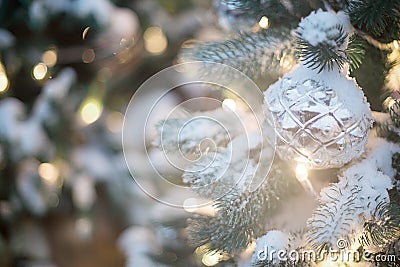 Silver ball on the Christmas tree with golden highlights and light bulbs Stock Photo