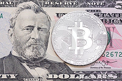 SIlver bitcoin on fifty dollas banknote. Stock Photo