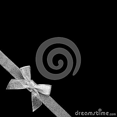 Silver bow with ribbon in the lower left corner. Close up. Isolated on black background Stock Photo