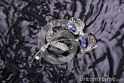 Silver brooch flower with blue stone in the water Stock Photo