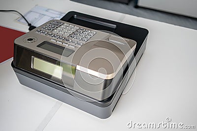 Silver cash register on white counter. Portable model cashing machine Stock Photo