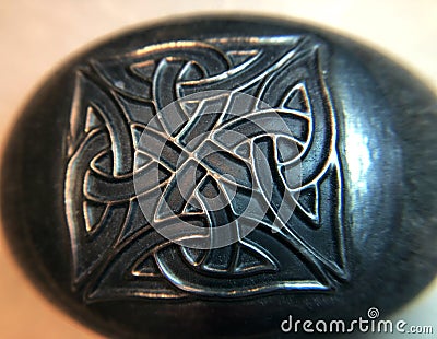 Silver Celtic knotwork design on stone Stock Photo