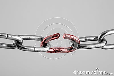 Silver chain with red broken link, concept of freedom. Stock Photo