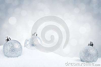 Silver Christmas baubles on snow with a silver background Stock Photo