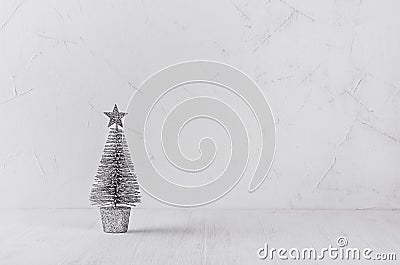 Silver christmas tree on white shabby plaster and wood background. Stock Photo