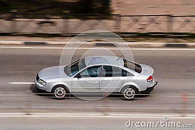 Silver color old Audi A6 C5 drive fast on city street. The car moves on the road with motion blur. Speeding in the city is not Editorial Stock Photo