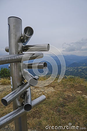 Silver-colored metal signpost in the mountains close-up across aerial mountains view. Adventure, travel lifestyle. Pietra di Bisma Stock Photo