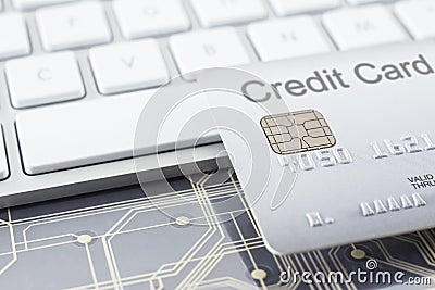 Silver credit card with digital circuits and keyboard Stock Photo