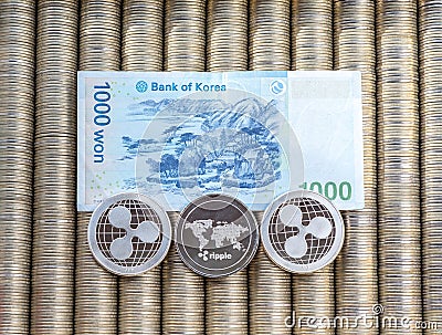 Silver crypto coins Ripple XRP, paper denominations Korean won. Metal coins are laid out in a smooth background to each other, clo Editorial Stock Photo