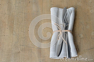 Cutlery with napkin decorated with a notation on a wooden board. Suitable as a background. Stock Photo