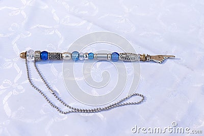 A silver, beaded yad, a pointer used to assist a Torah reader follow the Hebrew text when reading from a Torah scroll Stock Photo