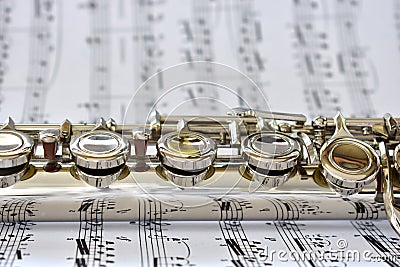 A silver flute on sheet music Stock Photo
