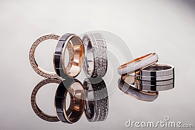 Silver, gold, platinum rings of different styles on the gray background of reflections Stock Photo