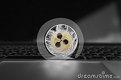 Silver gold ripple coin on a laptop keyboard closeup. Blockchain mining. Digital money and virtual cryptocurrency Editorial Stock Photo