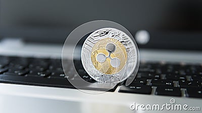 Silver gold ripple coin on a laptop keyboard closeup. Blockchain mining. Digital money and virtual cryptocurrency Editorial Stock Photo