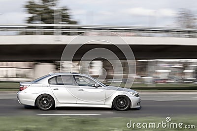 Silver gray car is driving on the street at high speed. Speeding in the city. Motion blur. Riga, Latvia - 02 Oct 2021 Editorial Stock Photo