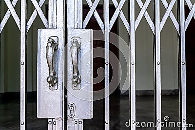 Silver iron fence entrance locked with classic metallic door handle Stock Photo