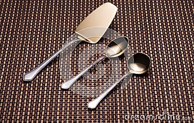 Silver kitchen utensils with golden spraying at the end. Stock Photo