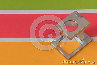 Silver magnifying glass standing on the test print, colored background. Print loupe on offset printed sheet with basic colors Stock Photo