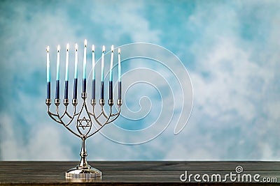 A silver menorah for the Jewish holiday Hanukkah with burning glowing eight candles Stock Photo