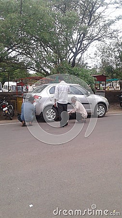 A silver Motorcar repairing on the main road, Solapur, Maharashtra Editorial Stock Photo