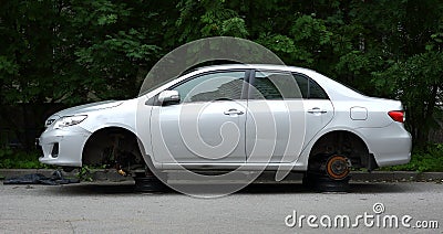 Silver passenger car without wheels on the street Stock Photo