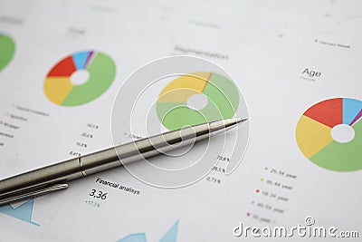 Silver pen lying at colorful financial graph Stock Photo