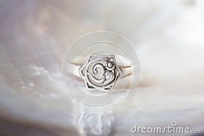 Silver ring tiny jewelry piece on white pearl background Stock Photo