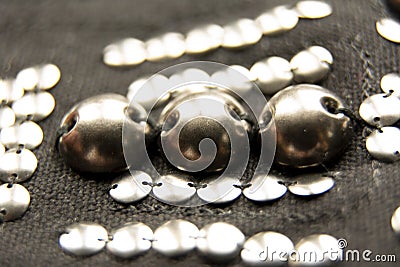 Silver shiny beads and sequins in vintage style are sewn on black coarse fabric Stock Photo