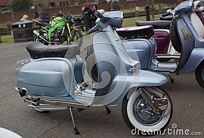 Silver shiny vintage grey motor scooter parked in Rye Editorial Stock Photo