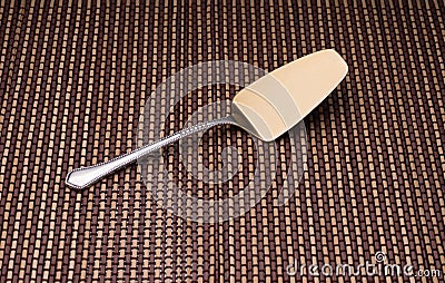 Silver shovel cake with golden spraying at the end on the mat. Stock Photo