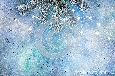 Silver sparkling confetti and silver fir tree branch on blue bac Stock Photo