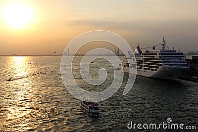 SILVER SPIRIT cruise ship moored, small excursion boat underway crossing the harbor at sunset in Venice, Italy Editorial Stock Photo