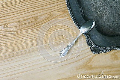 Silver Spoon On Floral Vintage Salver On Wooden Surface Stock Photo