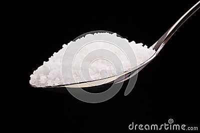 Silver spoon full of white crystal sugar. Stock Photo