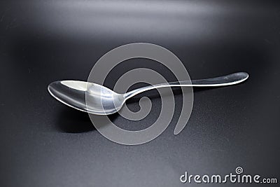 Silver spoon set against dark background Stock Photo