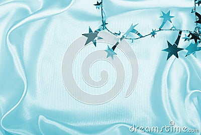 Silver stars and spangles on toned white silk as background Stock Photo