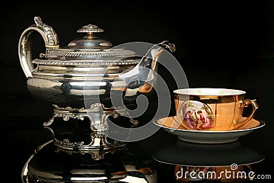 Silver teapot and an antique chinese cup of tea Stock Photo