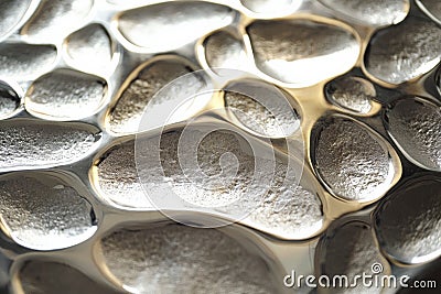 A silver textured surface with a dimpled pattern, creating a tactile, pebble-like texture across Stock Photo