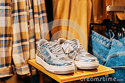 silver unisex sneakers shoes on shelf display in shop mall store. Store Of Shopping Center. retail sale Stock Photo